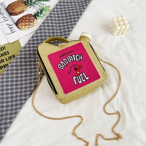 Macro detail of gold glitter fuel can bag with pink BadBitch Fuel embroidery and chain