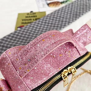Detailed close-up of pink sequin bag with gold double zippers and star patterns