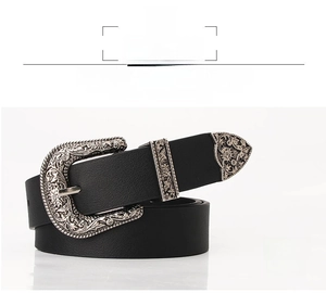 Detailed macro view of vintage floral engraved silver buckle on a black leather belt