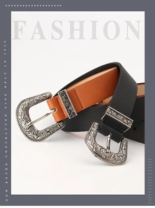Close-up of retro black and brown leather belts with carved baroque silver buckles