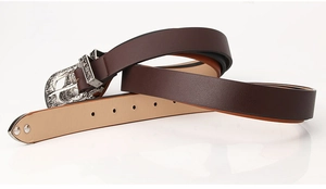 Detail of brown leather belt with vintage floral engraved silver metal buckle