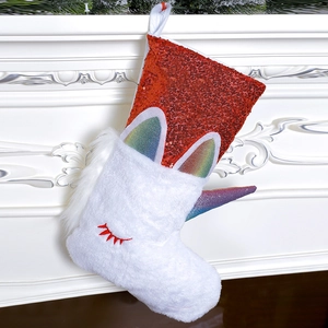 Plush unicorn Christmas stocking with red sequins hanging on a white fireplace mantle
