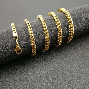Polished gold hip-hop Cuban link necklace with lobster clasp on a cylindrical stand