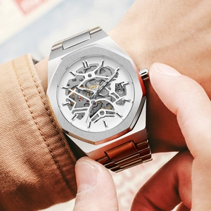 Close-up of an octagonal silver mechanical watch with a skeleton dial on a male wrist