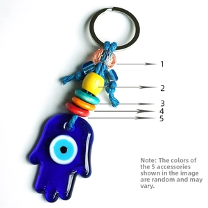 Macro shot of glass Evil Eye Hamsa Hand keychain with colorful wooden beads and metal ring