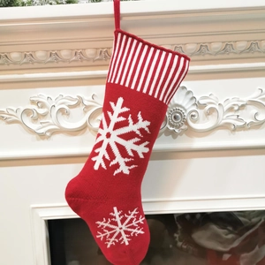 Detailed close-up of a red knitted Christmas stocking with white snowflake patterns