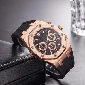 Close-up of men's chronograph watch with rose gold octagonal case and black rubber strap