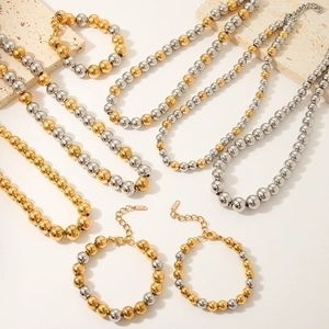 Elegant gold and silver beaded stainless steel necklaces and bracelets on stone decor