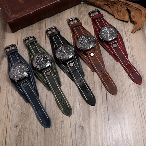 Cinq montres punk pour hommes avec larges bracelets en cuir sur fond de bois