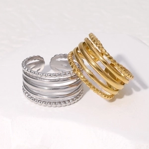 Minimalist geometric stacked stainless steel rings in gold and silver on white stone
