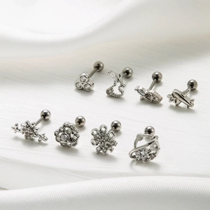 Set of 8 stainless steel cartilage studs with zircon inlays on white silk background