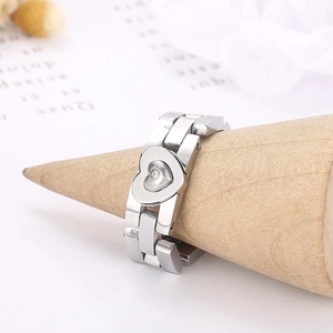 Silver stainless steel chain ring with heart-shaped center and inlaid zircon on a stand