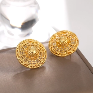 Macro view of gold woven dome stud earrings with intricate mesh texture detail