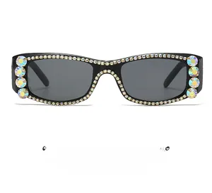 Detail of square black sunglasses featuring sparkling rhinestones and grey lenses