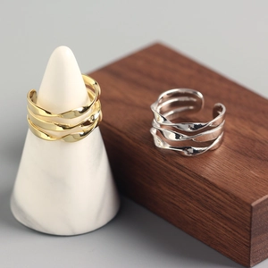 Detailed view of layered twist rings in gold and silver finish on display stands