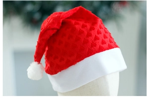 Close-up of red heart-patterned plush fabric and white pom-pom on festive Christmas hat