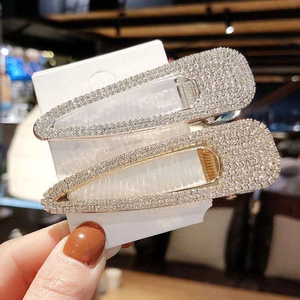 Close-up of sparkling rhinestone hair clips in gold and silver set on display card