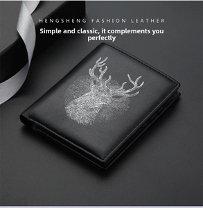 Detail of slim black leather wallet featuring a silver reindeer motif with gift box packaging