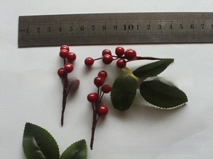 Detail of 15mm pearlescent berry branches with green leaves for Christmas DIY decor