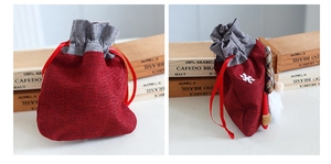 Detail of red linen Christmas gift bag with gnome decoration and snowflake patch