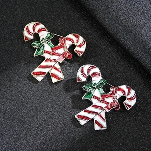 Two Christmas candy cane brooches with festive red and white stripes on black background