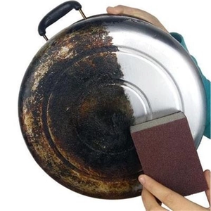 Heavy-duty brown emery sponge removing burnt stains and rust from stainless steel cookware
