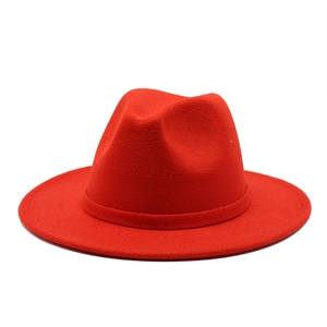 Detailed view of a classic red wool fedora hat with a wide brim and matching ribbon band