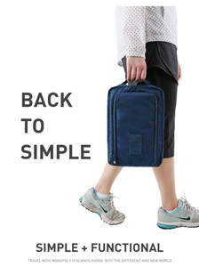 Detail of dark blue waterproof nylon travel shoe bag held by hand in lifestyle shot