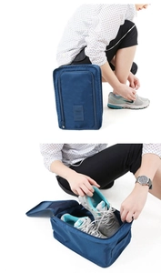 Detail showing waterproof navy nylon travel shoe storage bag with a durable handle and leather logo
