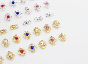 Detailed view of floral alloy nail charms with colorful crystals, pearls and 520 design