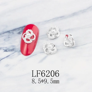 Detailed view of silver petal nail charms with pearl center and 8.5x9.5mm dimensions