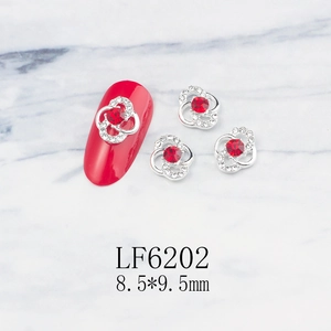 Detail of silver hollow flower nail charm with red crystal and 8.5x9.5mm dimensions