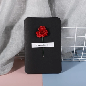 Close-up of handmade black greeting card with red 3D roses and Especially for you text