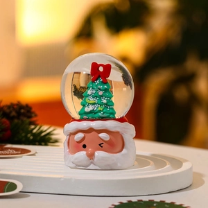 Detailed close-up of a Santa Claus resin base crystal ball with a festive Xmas tree inside