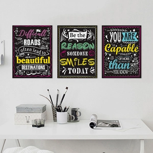 Three chalkboard style motivational posters with colorful English quotes on a white wall