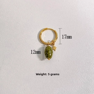 Détail de la boucle d'oreille dorée 17mm avec pierre naturelle verte et étoile