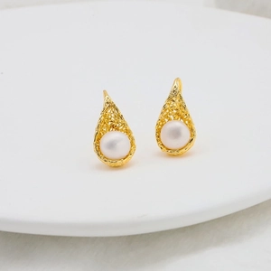 Macro view of water drop pearl earrings with golden hollow mesh in 18k gold plating