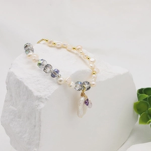 Macro view of natural freshwater baroque pearl and grey crystal bracelet on stone