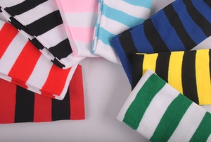 Macro shot of colorful striped knee-high stockings in multiple knit cotton blends