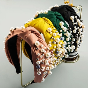 Detail of wide knotted headbands with pearls, metal beads, and fabric texture details