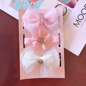 Detailed view of three-piece baby headband set featuring pink mesh bows and fabric flowers