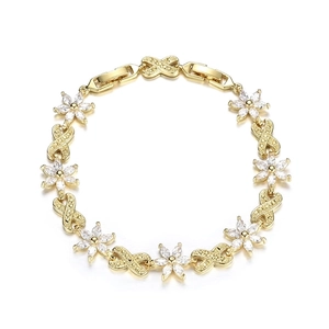 Macro detail of gold flower bracelet with zircon stones and infinity link design