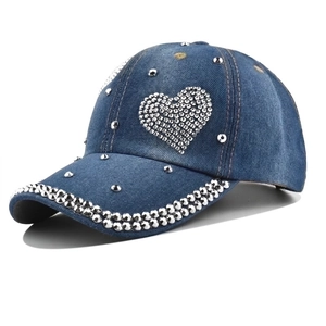 Denim baseball cap for women with rhinestone heart pattern and silver rivets on a white background