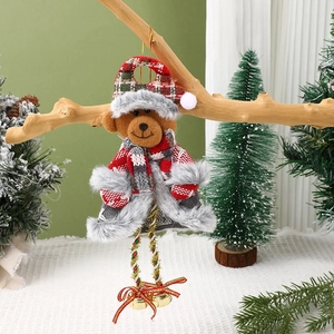 Detail of plush Christmas bear ornament with red plaid hat and bells on a wooden branch