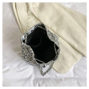 Top view of silver sequin bucket bag featuring chain strap and black lining interior