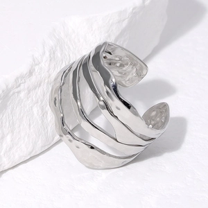 Irregular silver stainless steel layered ring with hammer texture on a stone base