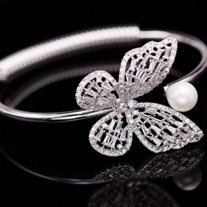 Detailed view of silver butterfly bangle with sparkling zircons and a white pearl accent