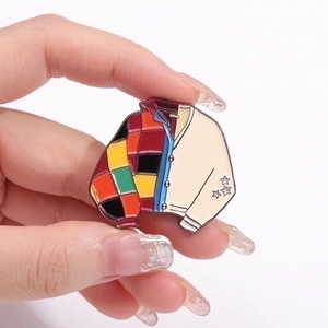Colorful geometric patchwork cardigan enamel pin featuring silver star sleeve details