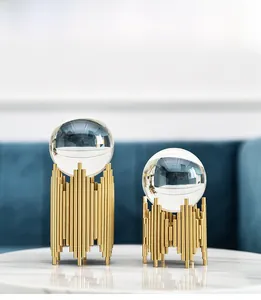 Detail of luxury crystal balls with gold organ-style metal bases on marble surface