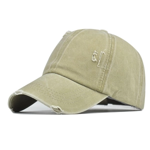 Detail of khaki washed cotton ponytail cap featuring distressed vintage ripped brim effects